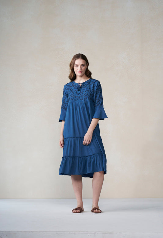 Woman wearing a blue dress against a plain background