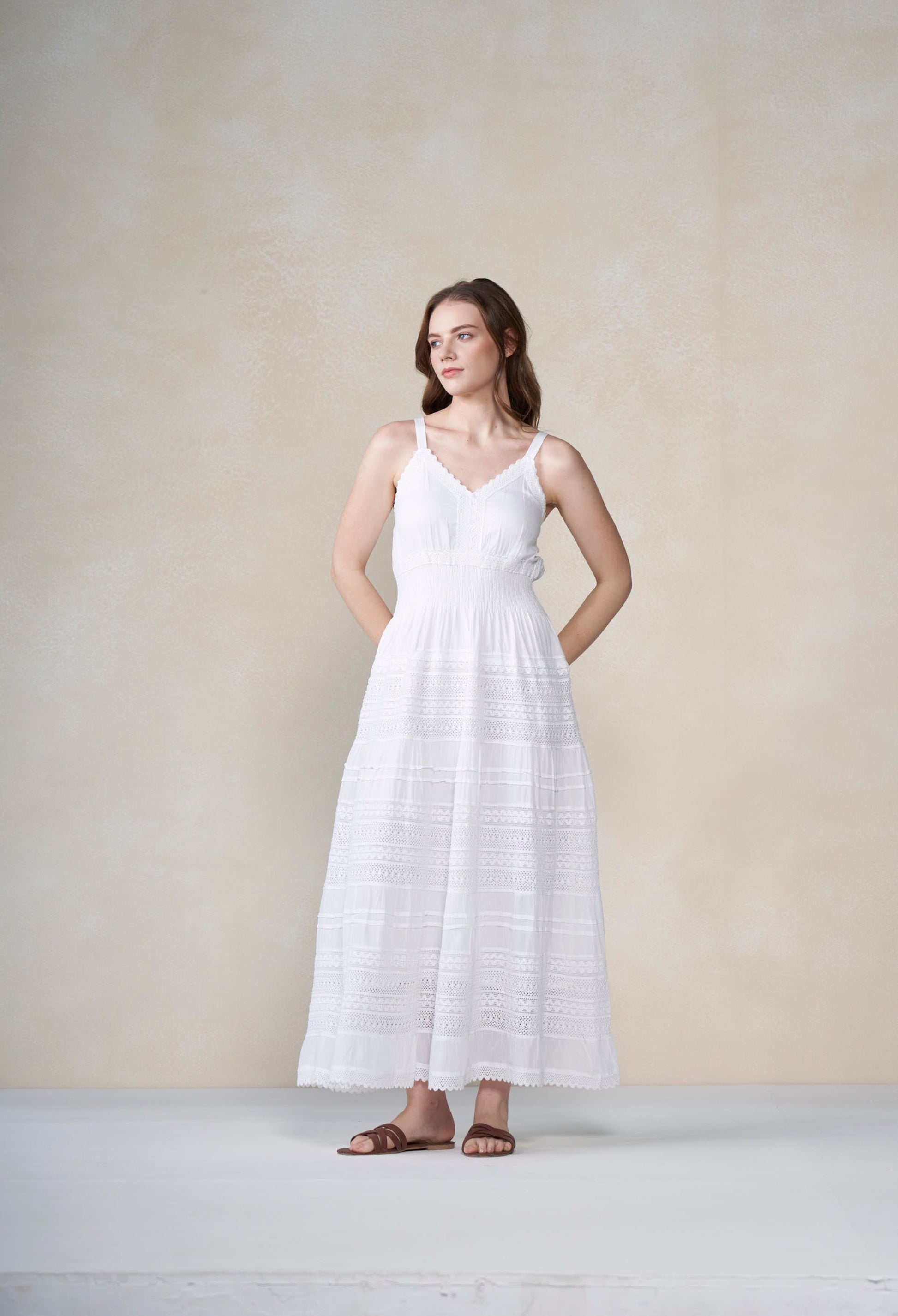 Woman wearing a white dress against a plain background