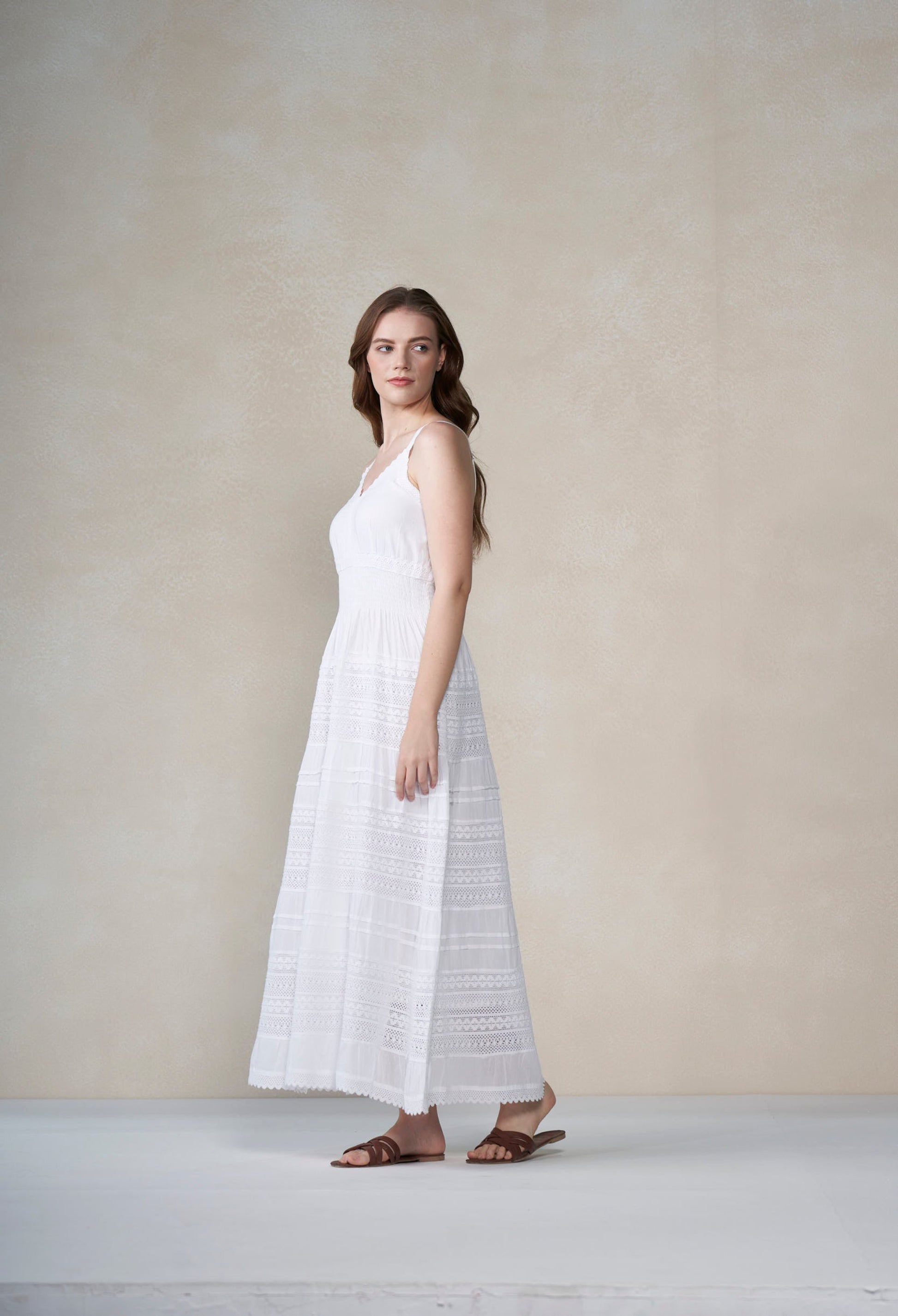 Woman wearing a white dress against a plain background