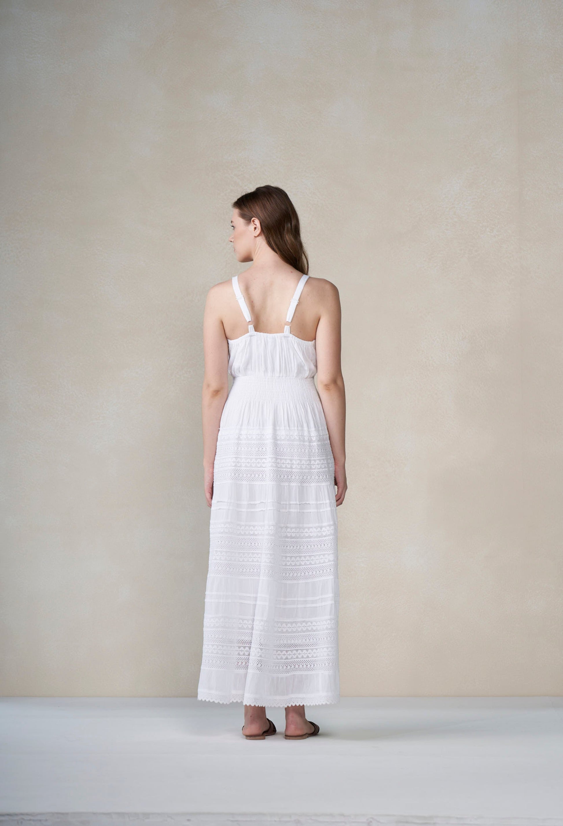 Woman wearing a white dress against a plain background