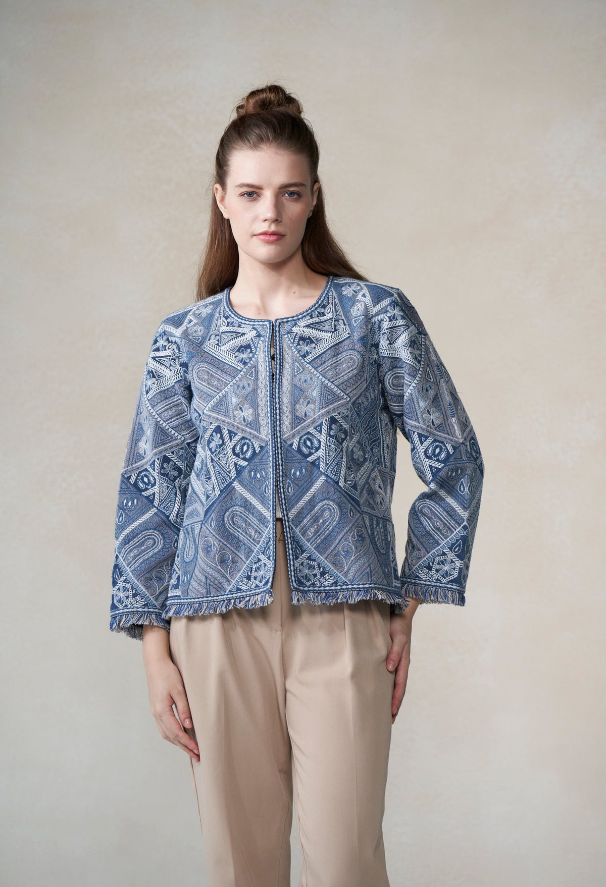 Woman wearing a blue patterned jacket against a plain background