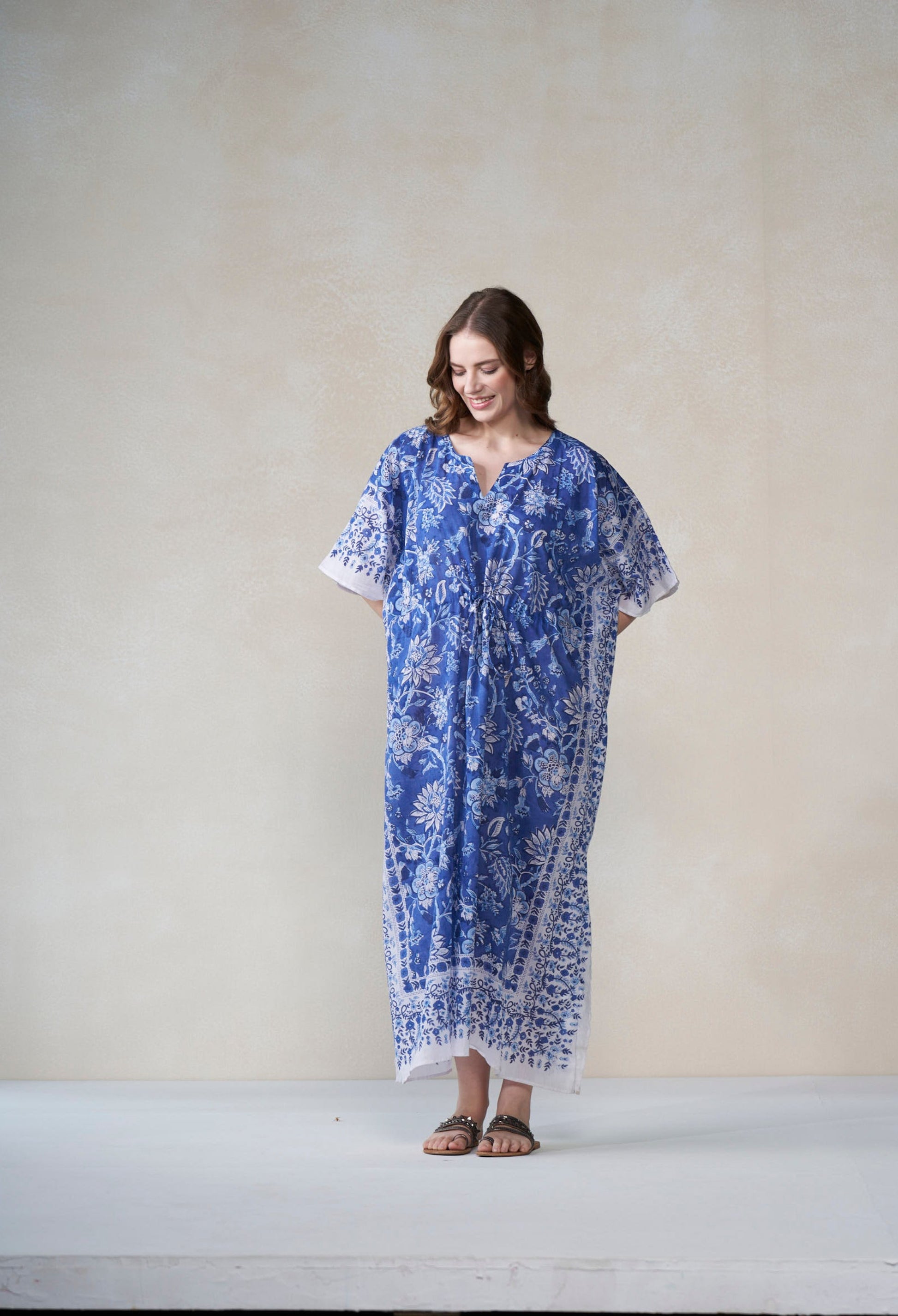 Woman wearing a blue patterned dress against a plain background
