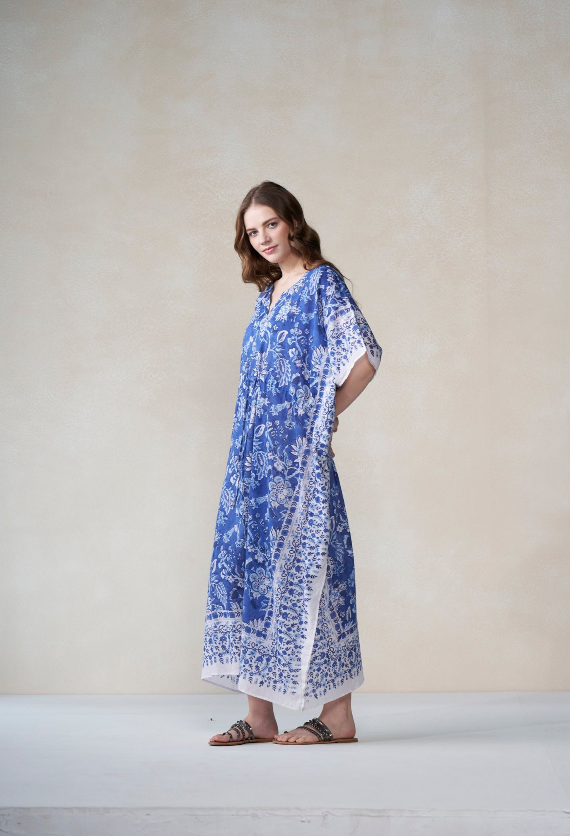 Woman wearing a blue and white patterned dress against a plain background