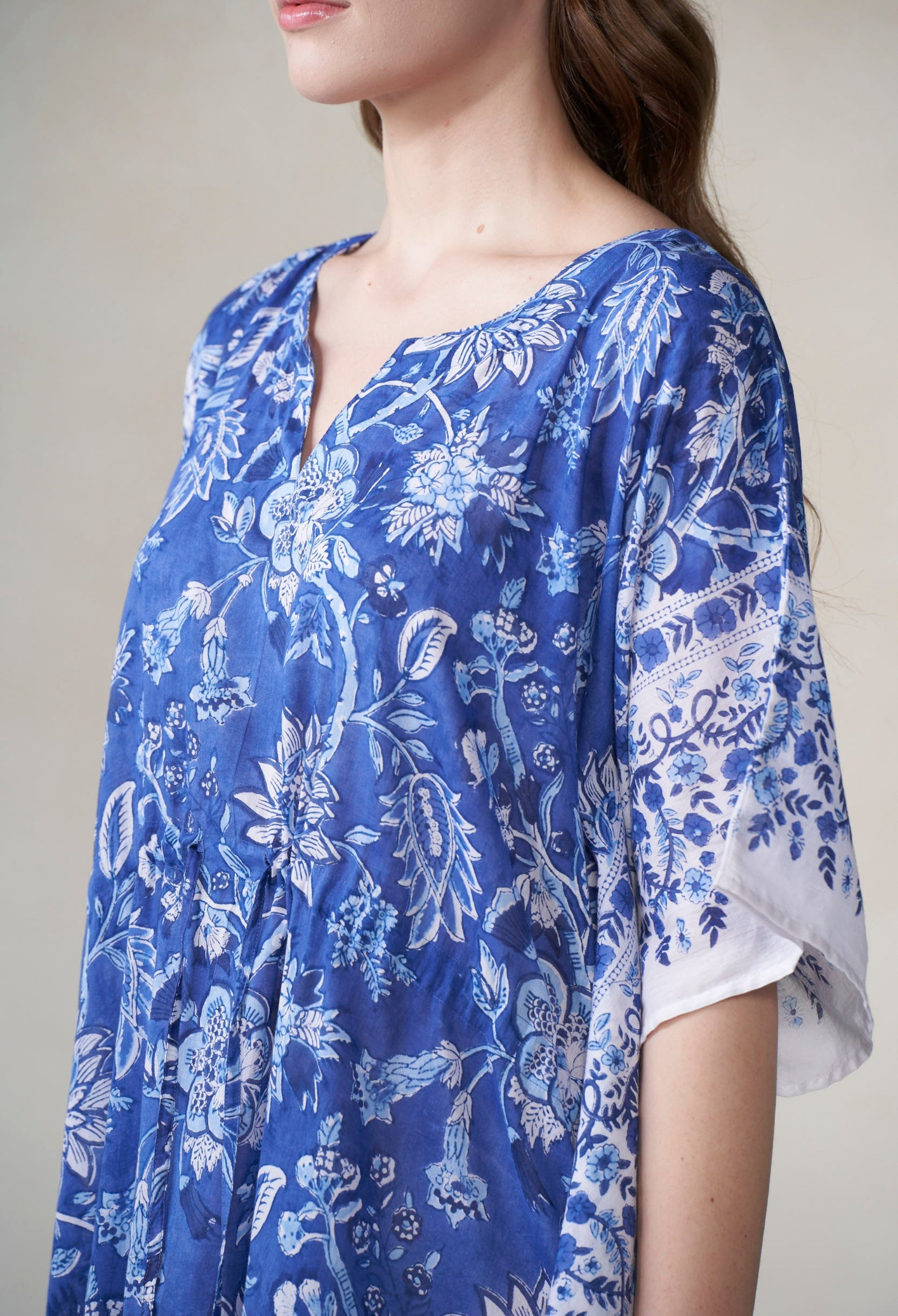 Blue floral kimono-style garment worn by a person on a plain background