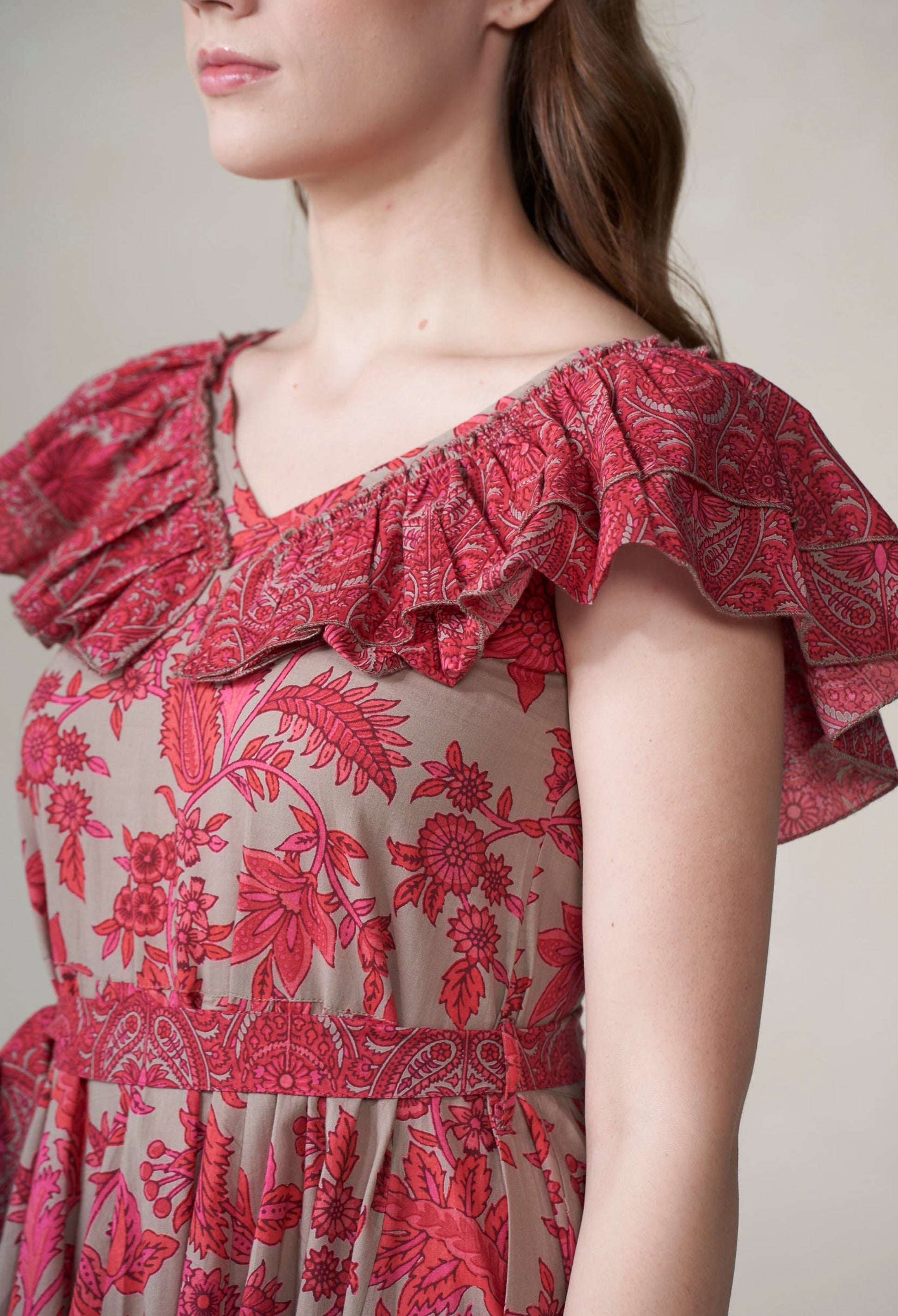 Red floral dress with ruffled neckline on a neutral background