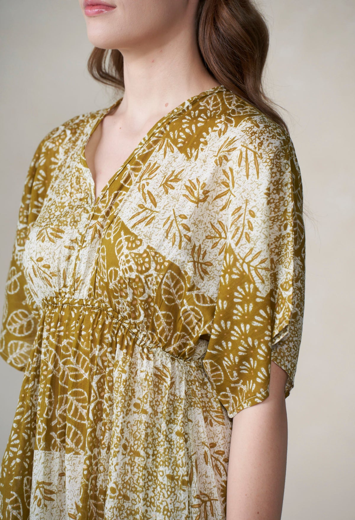 Woman wearing a floral patterned dress with a neutral background