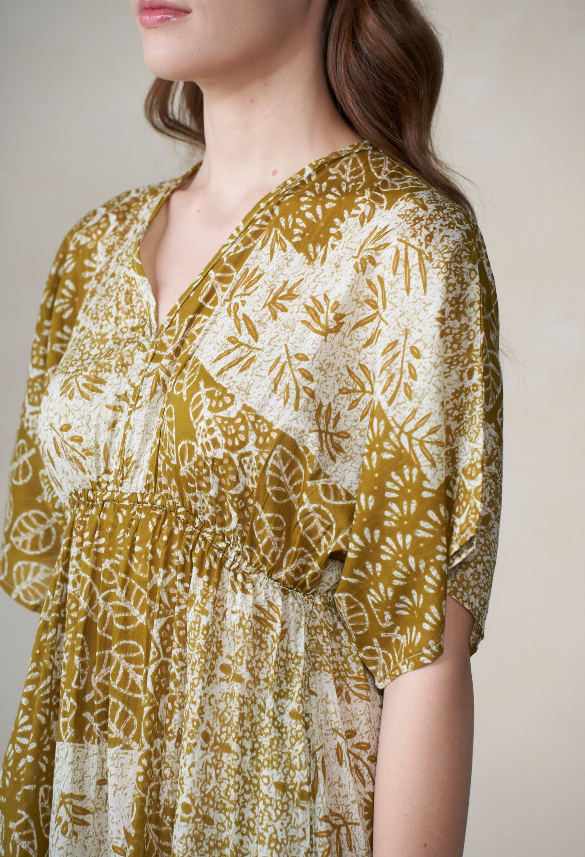 Woman wearing a floral patterned dress with a neutral background