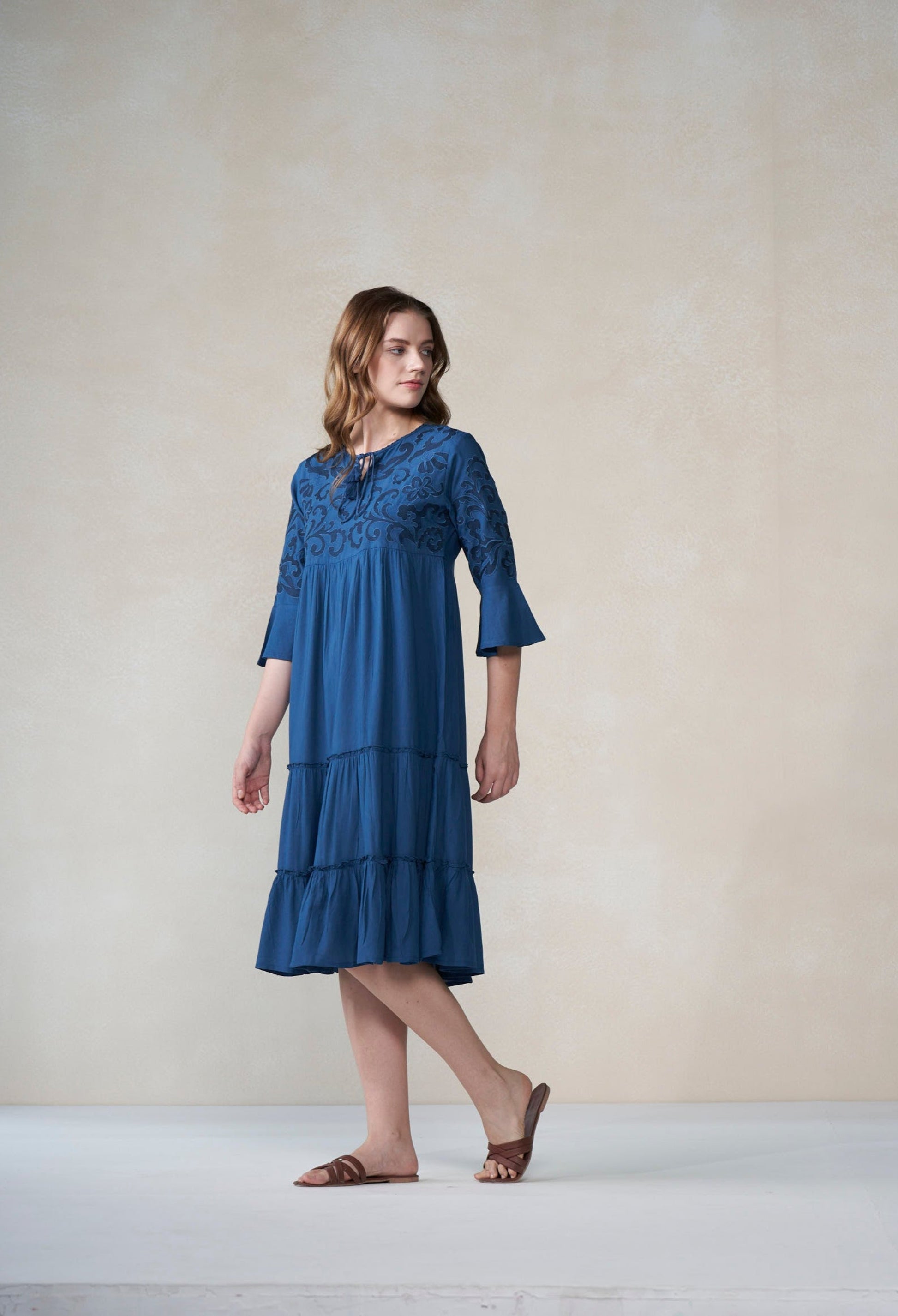 Woman wearing a blue dress against a plain background