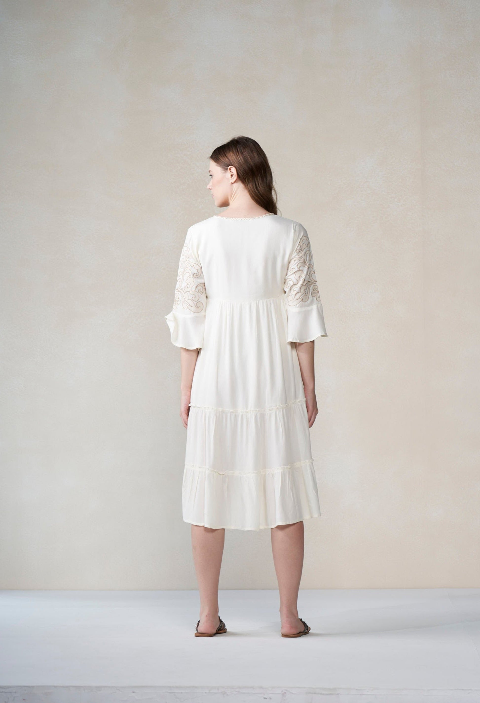 Woman wearing a white dress against a plain background