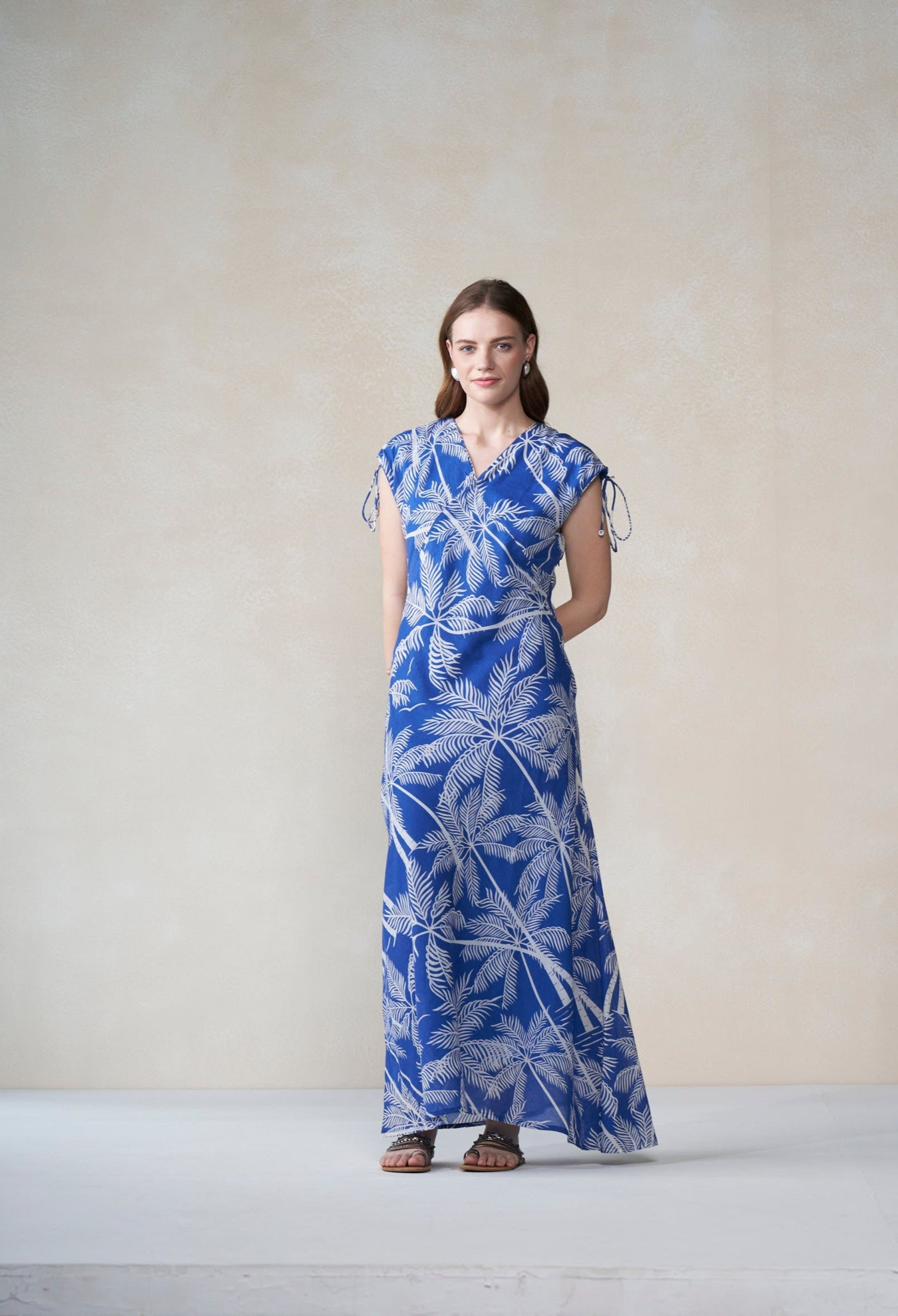 Woman wearing a blue and white patterned dress against a plain background