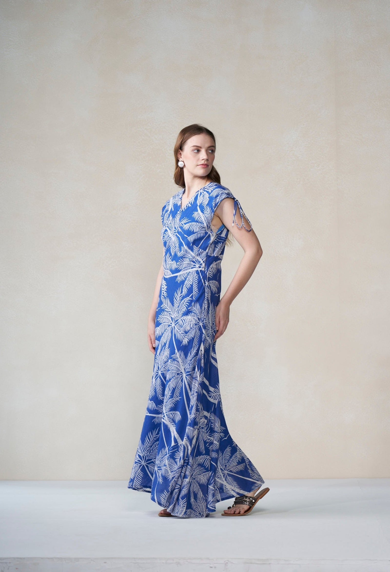 Woman wearing a blue floral dress on a plain background