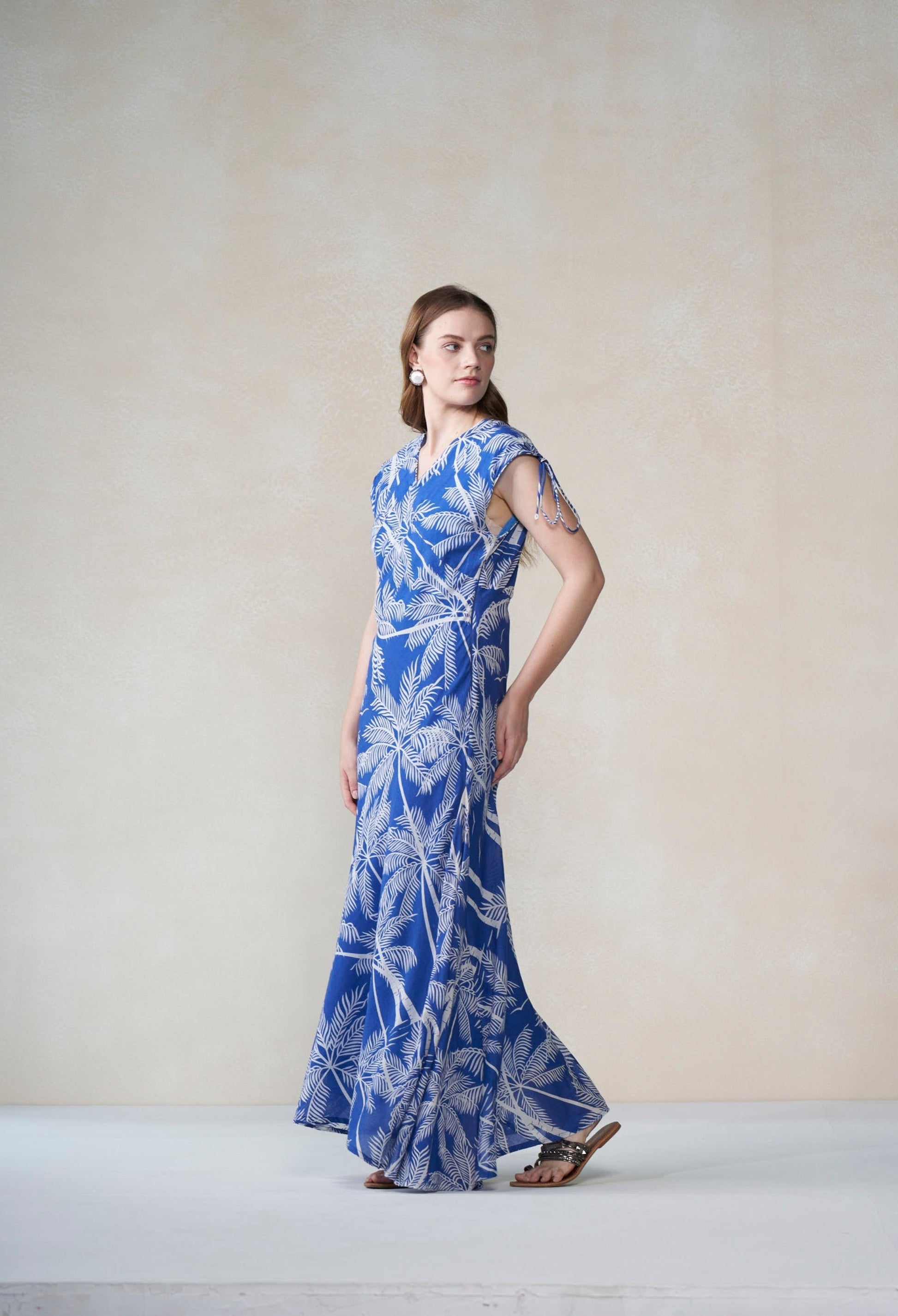 Woman wearing a blue floral dress on a plain background