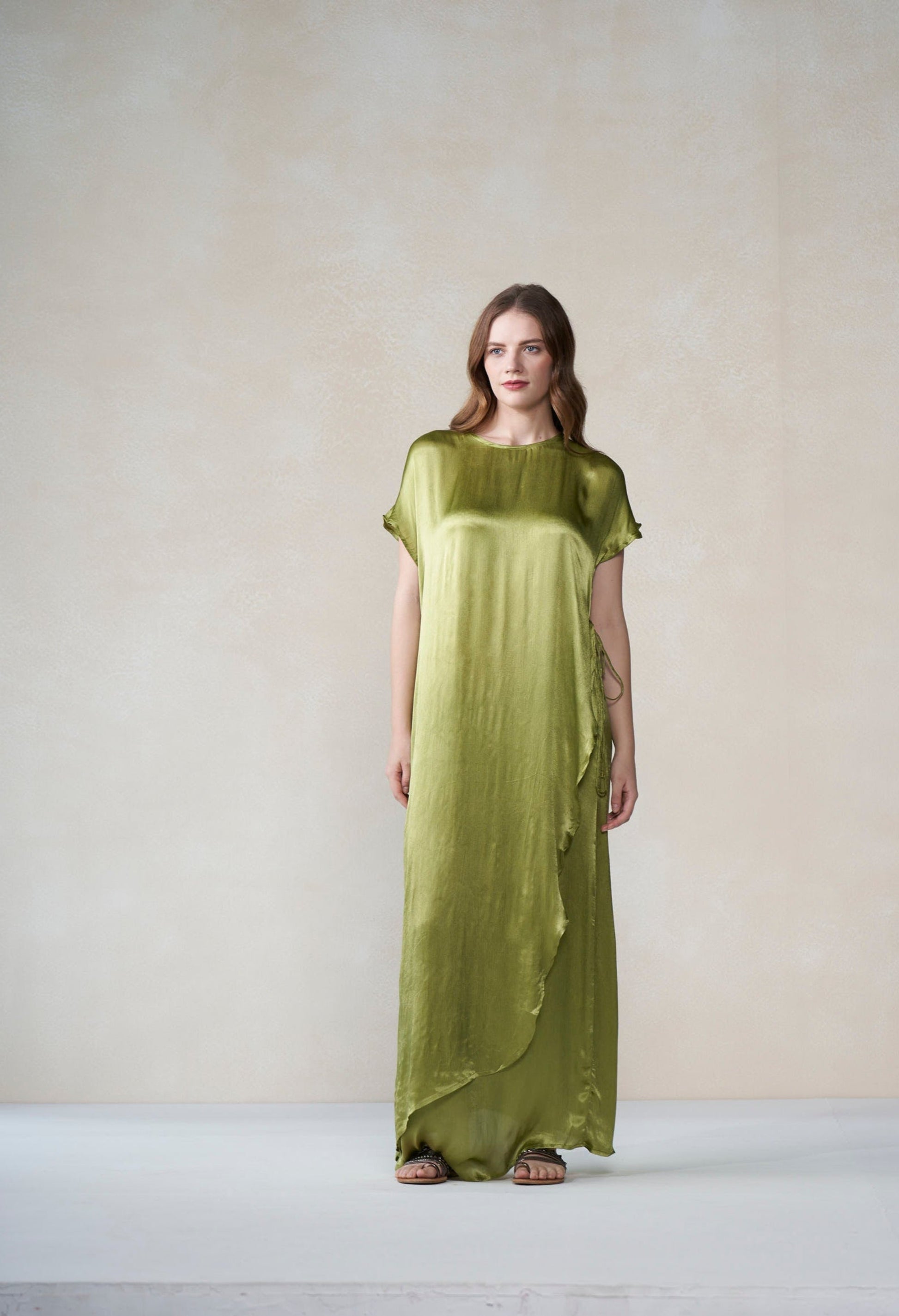 Woman wearing a green dress against a plain background