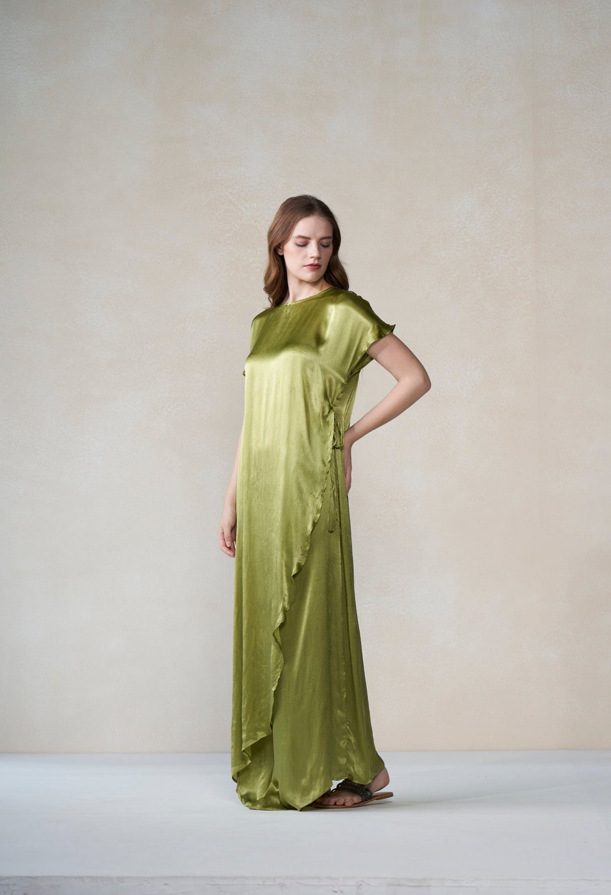 Woman wearing a green dress against a plain background
