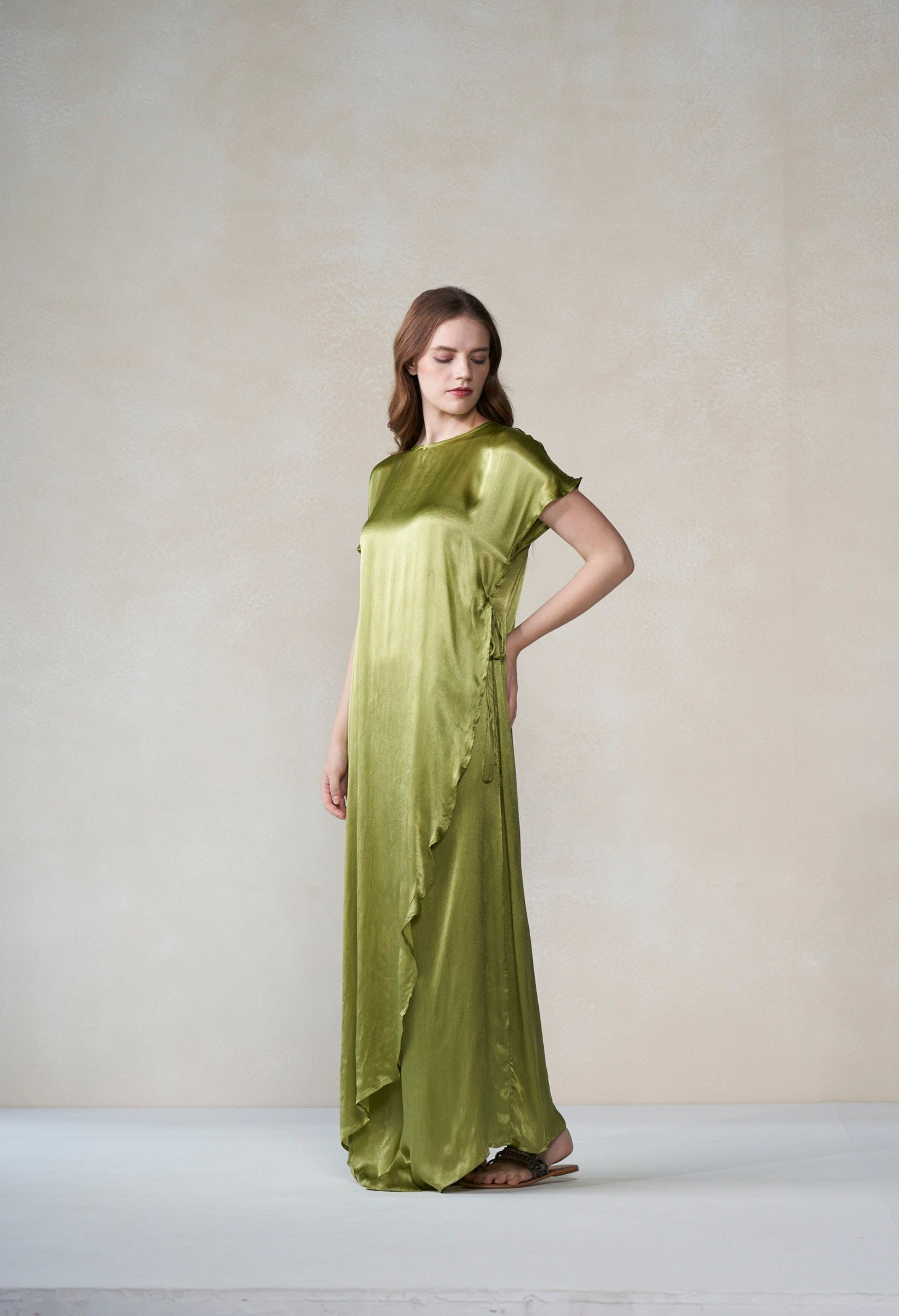 Woman wearing a green dress against a plain background