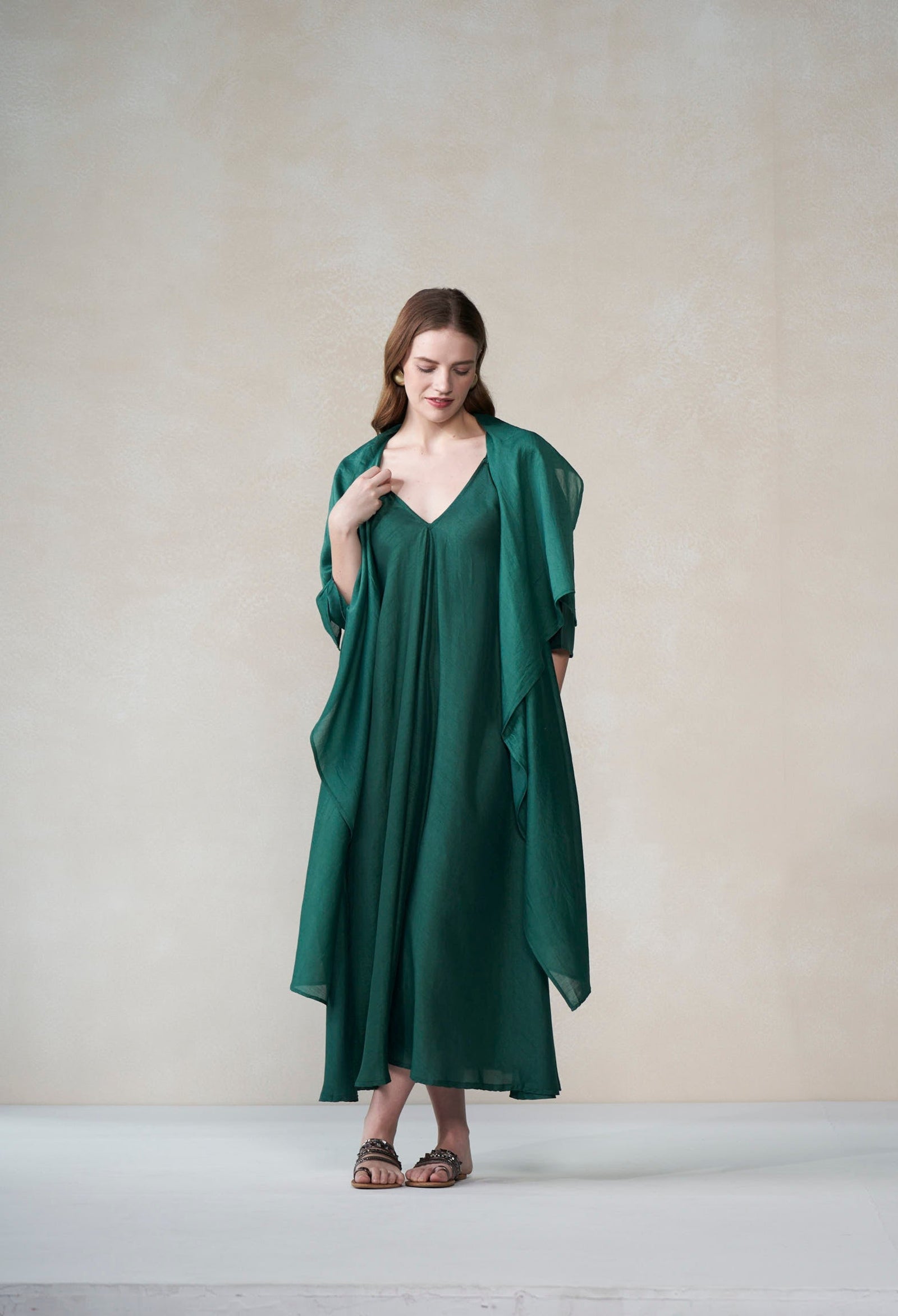 Woman wearing a green dress against a plain background