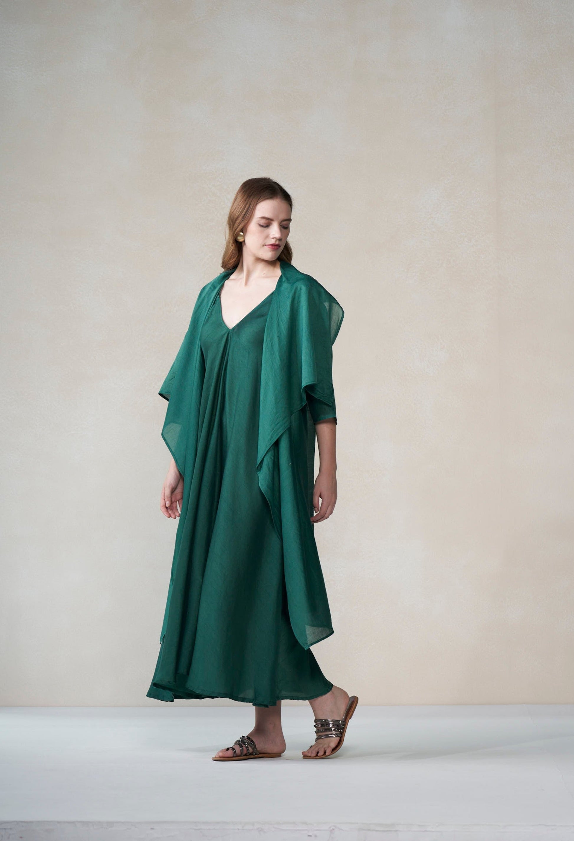 Woman wearing a green dress against a plain background