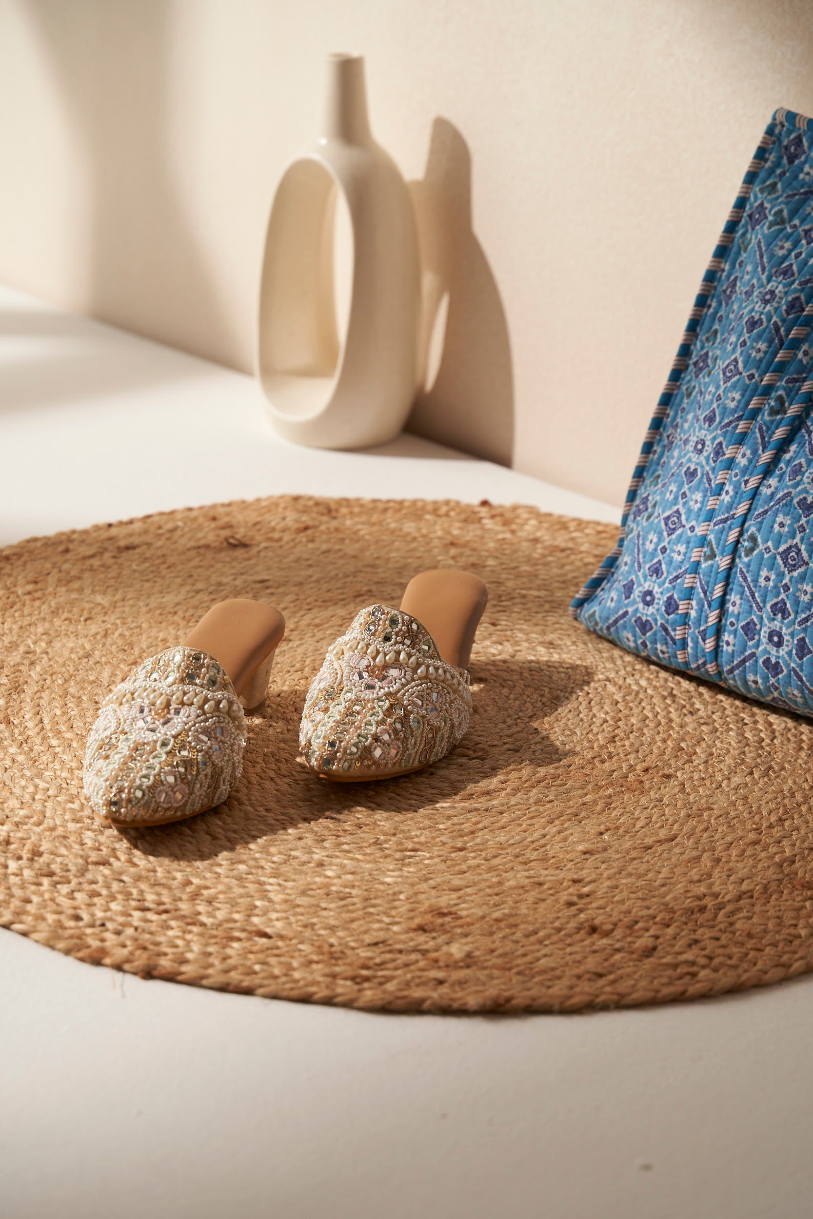 Decorated Indian Mules with beautiful embellishment on a beige mat.  