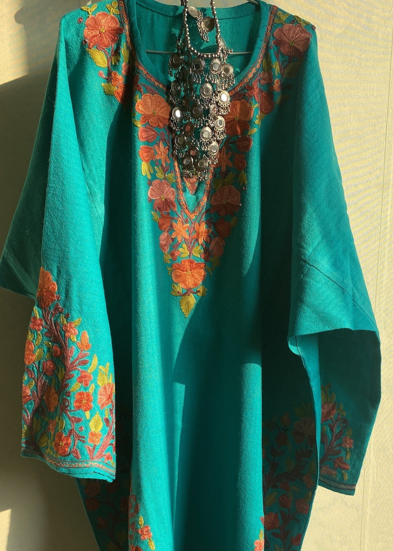 Teal fabric with floral patterns on a beige surface